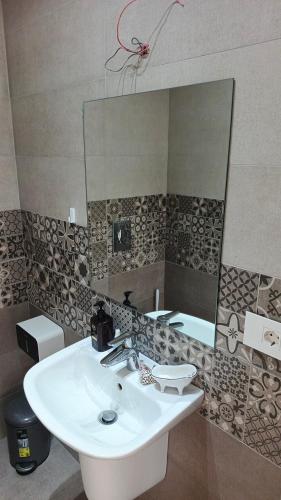 a bathroom with a sink and a mirror at Cozy Quiet escape from the City in Fatqā