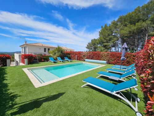 une piscine avec des chaises longues et une maison dans l'établissement New villa in Le Castellet with pool Superb view Villa neuve au Castellet avec piscine et superbe vue, au Castellet