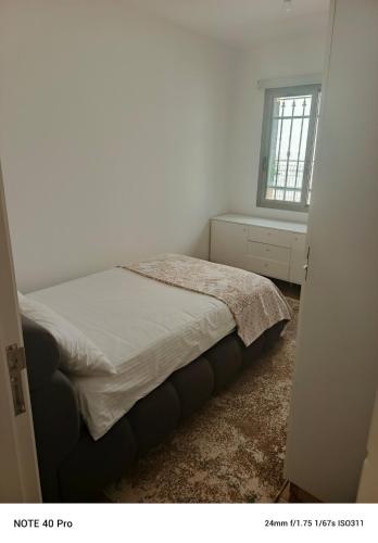 a bedroom with a bed and a window at Cozy Quiet escape from the City in Fatqā