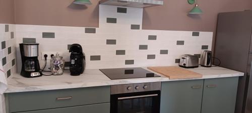 Il comprend une cuisine équipée d'un évier et d'une cuisinière. dans l'établissement Gîte la pause picarde, à Franleu