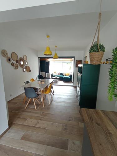 une cuisine et une salle à manger avec une table et des chaises dans l'établissement La maisonnette de Gaby, à Saint-Hilaire-de-Riez