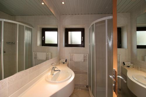 a bathroom with two sinks and a shower at Hotel Flores in Poreč