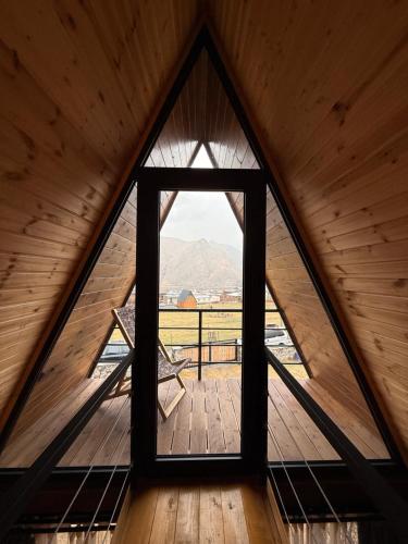 a window in a cabin with a view of a mountain at Sanseco Cottage in Stepantsminda