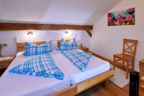 a bedroom with a white bed with blue pillows at Bauernhof Berndlhof Obing in Obing