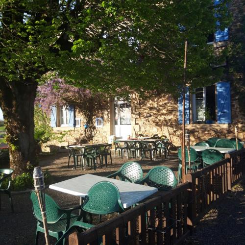 un groupe de tables et de chaises devant un bâtiment dans l'établissement chambre dhote condat sur ganaveix, à Condat-sur-Ganaveix