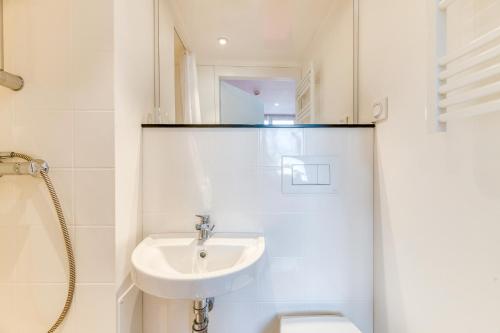 a white bathroom with a sink and a toilet at Logis Les Forges in Arvillard