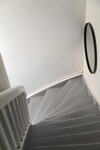 a spiral staircase with a mirror on the wall at Stort hus med 7 soverom på Eik in Tønsberg