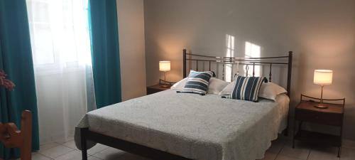 une chambre avec un lit avec des oreillers et deux lampes dans l'établissement Nerissa Bungalows No 5, à Spartià