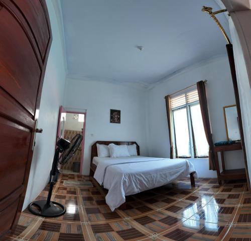 a bedroom with a bed and a large window at Zico Homestay in Andalas