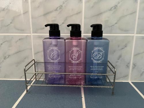 three bottles of soap on a rack in a bathroom at Sunrise terrace kintown in Kin