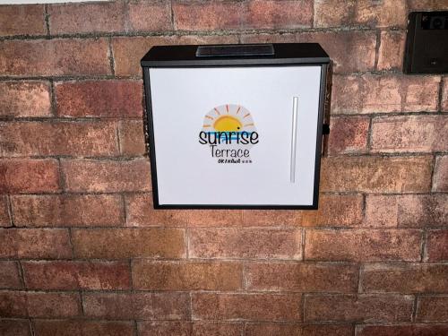 a picture of a sign on a brick wall at Sunrise terrace kintown in Kin