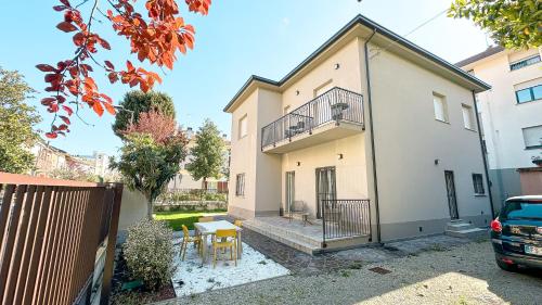 a house with a balcony and a table in a yard at Serenity Suites Rimini - Affitti Brevi Italia in Rimini