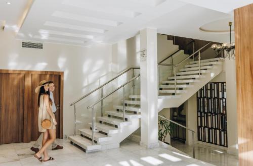 a woman standing in a hallway next to a staircase at Hotel Corsica & Spa Serena in Calvi