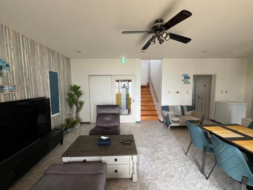 a living room with a couch and a ceiling fan at Sunrise terrace kintown in Kin