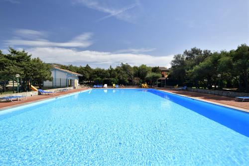a large swimming pool with blue water at Casa Vacanze Vista Mare-Piscina - PORTO ROTONDO in Porto Rotondo