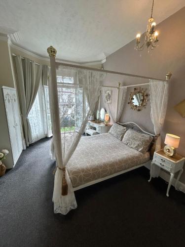 a bedroom with a canopy bed and a window at The Little Emily Guest House in Great Yarmouth