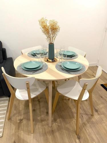 une table en bois avec des chaises, des assiettes et un vase dans l'établissement Chic & Moderne 3 min Vieux-Port & Panier 4P, à Marseille