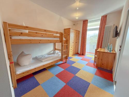 a room with a bunk bed and a checkered floor at Hotel Hochsauerland 2010 in Willingen