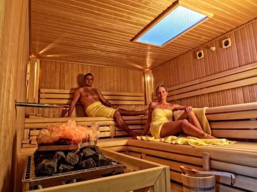 a man and a woman sitting in a sauna at Rebhan's Klassik in Stockheim Oberfranken