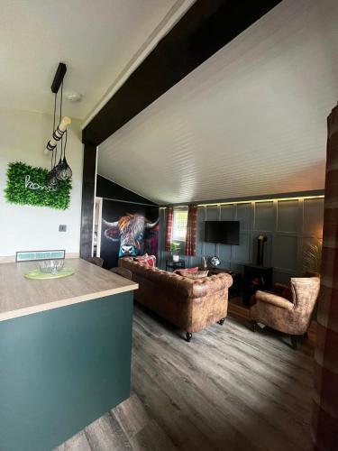 a living room with a couch and a table at Appin Holiday Homes -Caravans, Lodges, Shepherds Hut and Train Carriage stays in Appin
