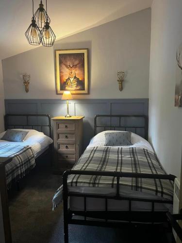 a bedroom with two beds and a lamp on a night stand at Appin Holiday Homes -Caravans, Lodges, Shepherds Hut and Train Carriage stays in Appin