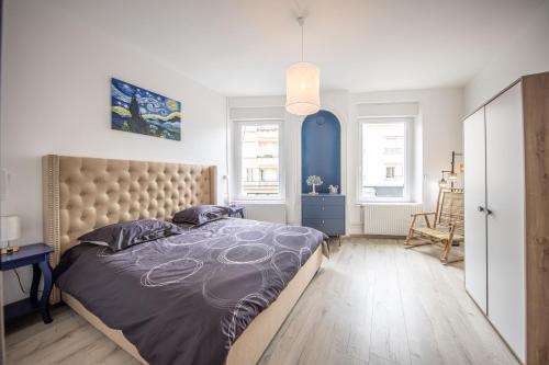 une chambre avec un grand lit et un mur bleu dans l'établissement Le Blue Chic - Nancy Thermal, à Nancy