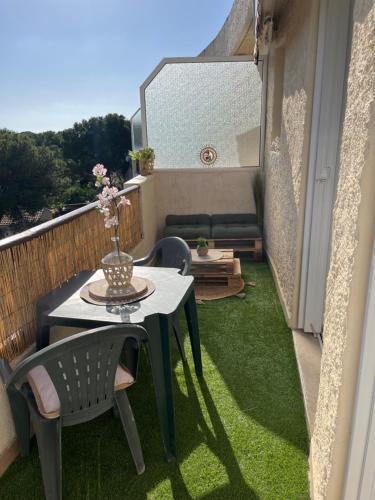 Elle comprend un petit balcon avec une table et des chaises sur gazon. dans l'établissement Les cigales de Fabregas, à La Seyne-sur-Mer