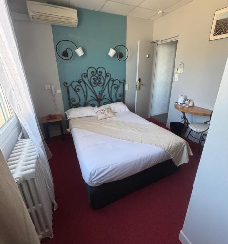 a bedroom with a large bed in a room at Le Régence in Arles