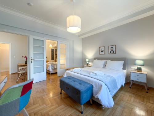 1 dormitorio con 1 cama grande con reposapiés azul en Acropolis view 4 bedroom flat, en Atenas