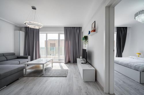 sala de estar blanca con sofá y cama en Rose Residence 1-1BR Apt-Parking, en Voluntari