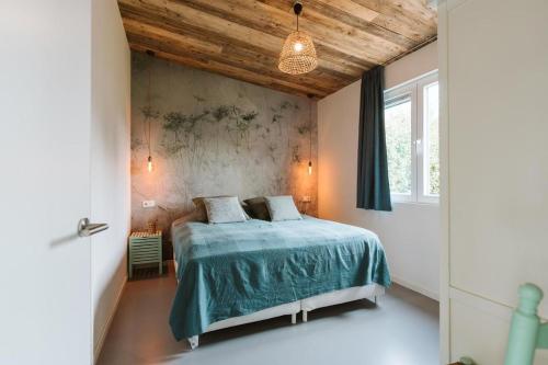 a bedroom with a bed with a green comforter at Vakantiewoning nabij zandstrand Ouddorp VP026 in Ouddorp
