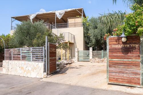 a house with a wooden gate and a fence at Country lodging in Manot in Manot