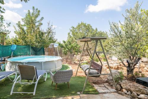 a backyard with a swing and a pool at Country lodging in Manot in Manot