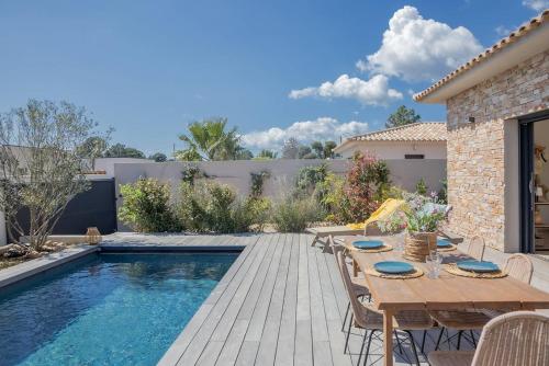 un patio avec une table et des chaises à côté d'une piscine dans l'établissement Villa 3 chambres avec piscine privative, à Porto-Vecchio