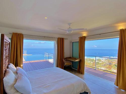 a bedroom with a bed and a view of the ocean at Villa Vavangue in Saint-Gilles les Bains