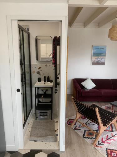 un salon avec un canapé rouge et un miroir dans l'établissement Duplex avec terrasse à 10 minutes à pied de la plage, à Villers-sur-Mer