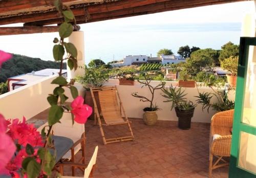 a balcony with a table and chairs and plants at Casa Pomelia - in centro a Malfa in Malfa