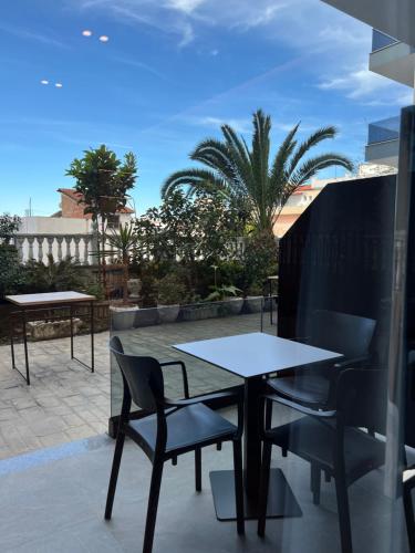 a table and chairs on a patio with palm trees at Villa Xika in Sarandë