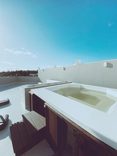 a hot tub on the roof of a building at Stylish 2-Beds beach side apart with common pool Post Lafayette in Roches Noires