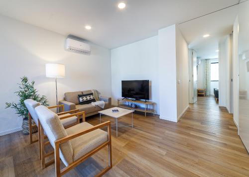 a living room with a couch and a tv at The Green Tiles Apartment incl Parking by Home Sweet Home Aveiro in Aveiro