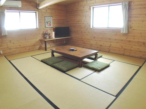 a living room with a table and some windows at Sendaiya in Hida