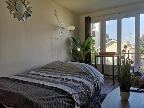 une chambre avec un lit et une grande fenêtre dans l'établissement Le Coin Parfait l Partner Loc, à Antony