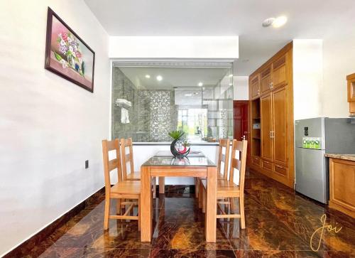 a kitchen with a wooden table and chairs in a room at Kim Minh Apartment & Hotel in Vung Tau