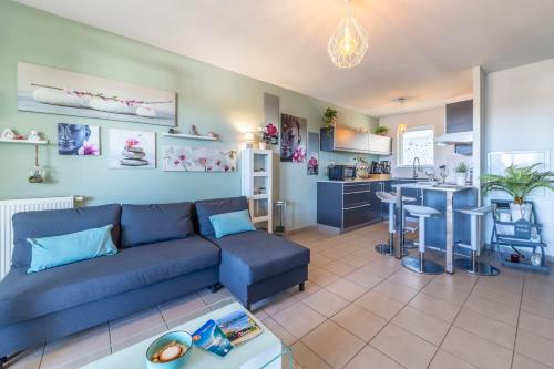 un salon avec un canapé bleu et une cuisine dans l'établissement The Boucau Lodge - Calm - Near to Beach, à Boucau