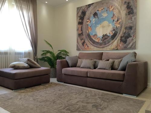 a living room with a brown couch and a painting at San Nicolò 3 in Verona
