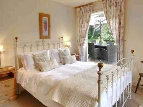 een slaapkamer met een wit bed en een raam bij Beaver Cottage in Thirsk