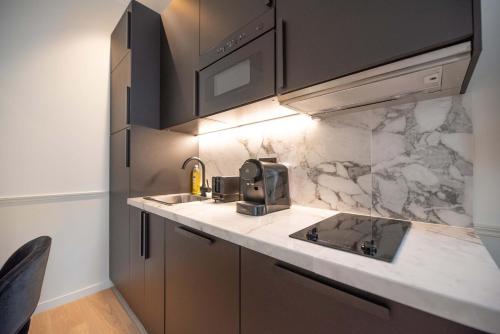 une cuisine avec un évier et un micro-ondes dans l'établissement Appartement de luxe dans le centre de Paris 2-4p, à Paris