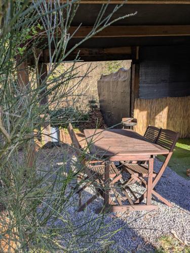a wooden picnic table and chairs in a yard at Chalet - l'Endoxyle in Froid-Chapelle
