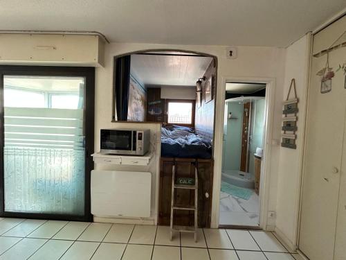 une petite cuisine avec un évier et un micro-ondes dans l'établissement Studio centre-ville, à Capbreton