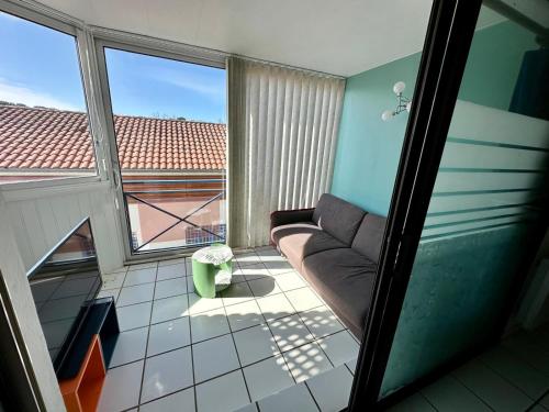 un salon avec un canapé et une grande fenêtre dans l'établissement Studio centre-ville, à Capbreton